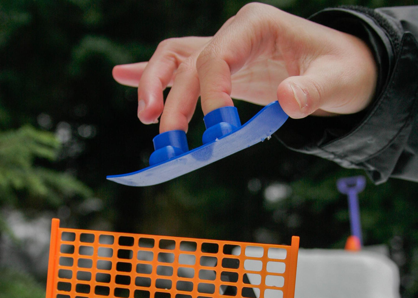 SlideofHand Finger Snowboard Blue on someones hand jumping in air