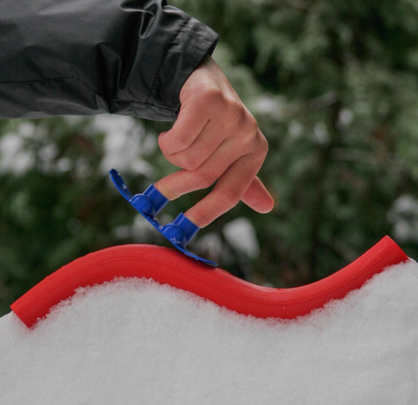 SlideofHand Finger Snowboard blue in someones fingers on a red rail
