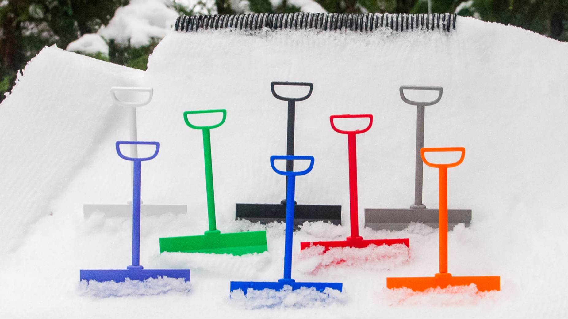SlideofHand mini ski terrain park rake assorted colors in the snow in front of a tube rail feature