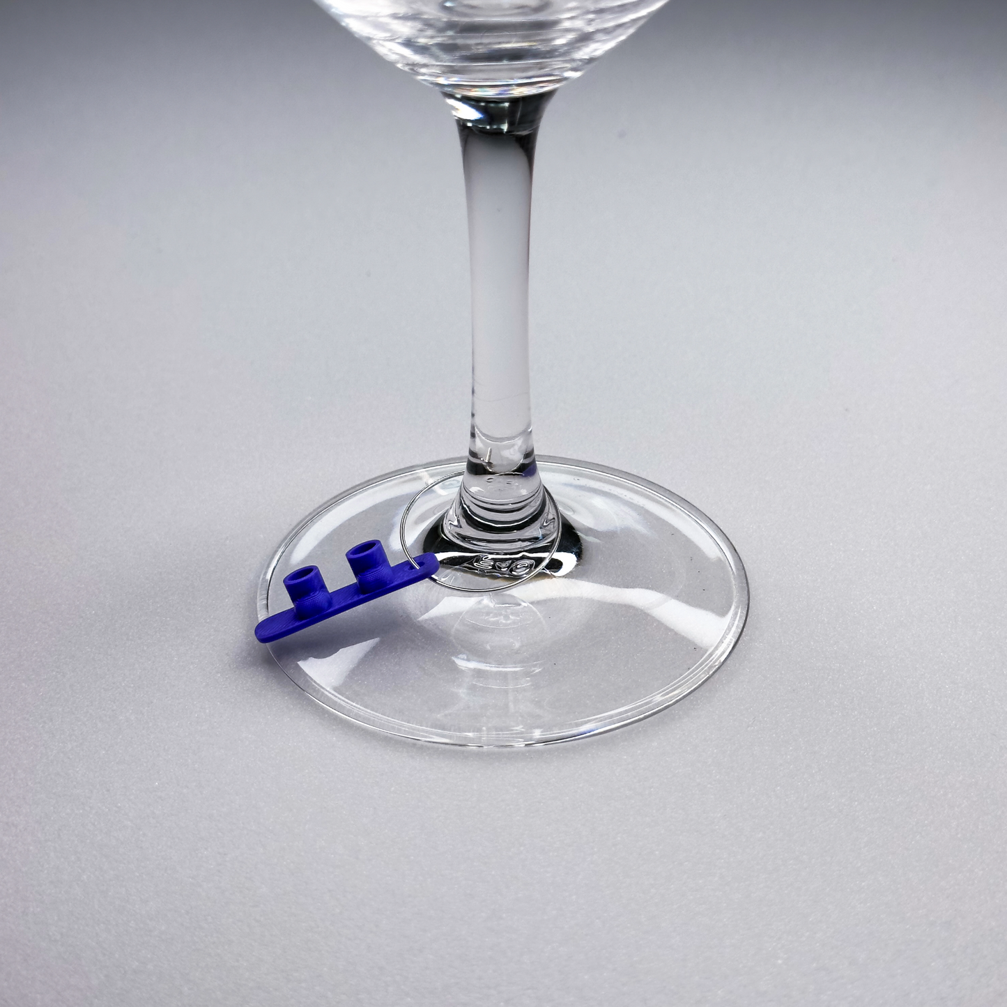 slideofhand snowboard blue wine charm on a closeup of a wine glass