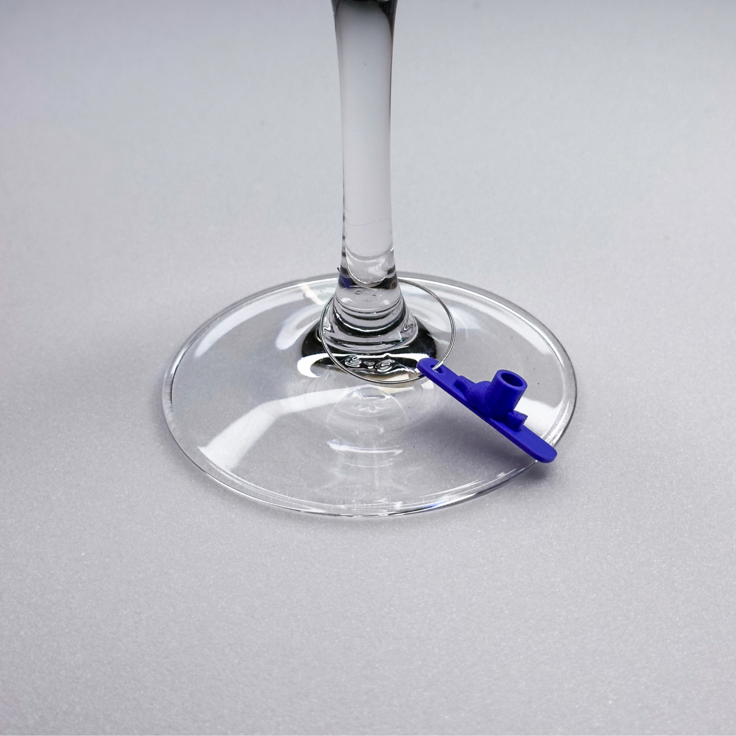 Slideofhand ski wine charm on a closeup of a wine glass
