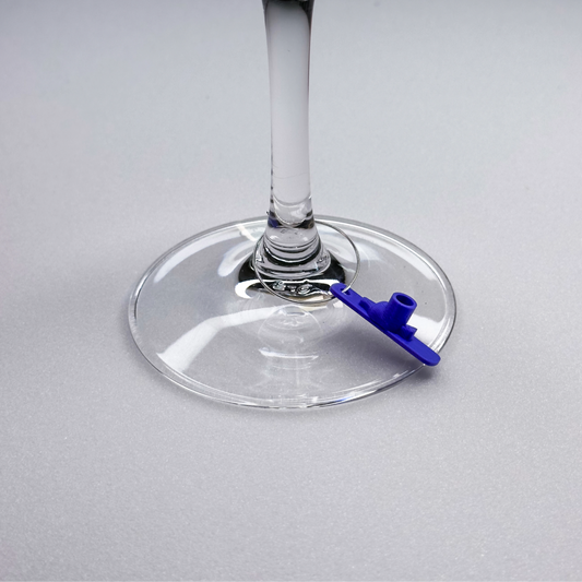 Slideofhand ski wine charm on a closeup of a wine glass