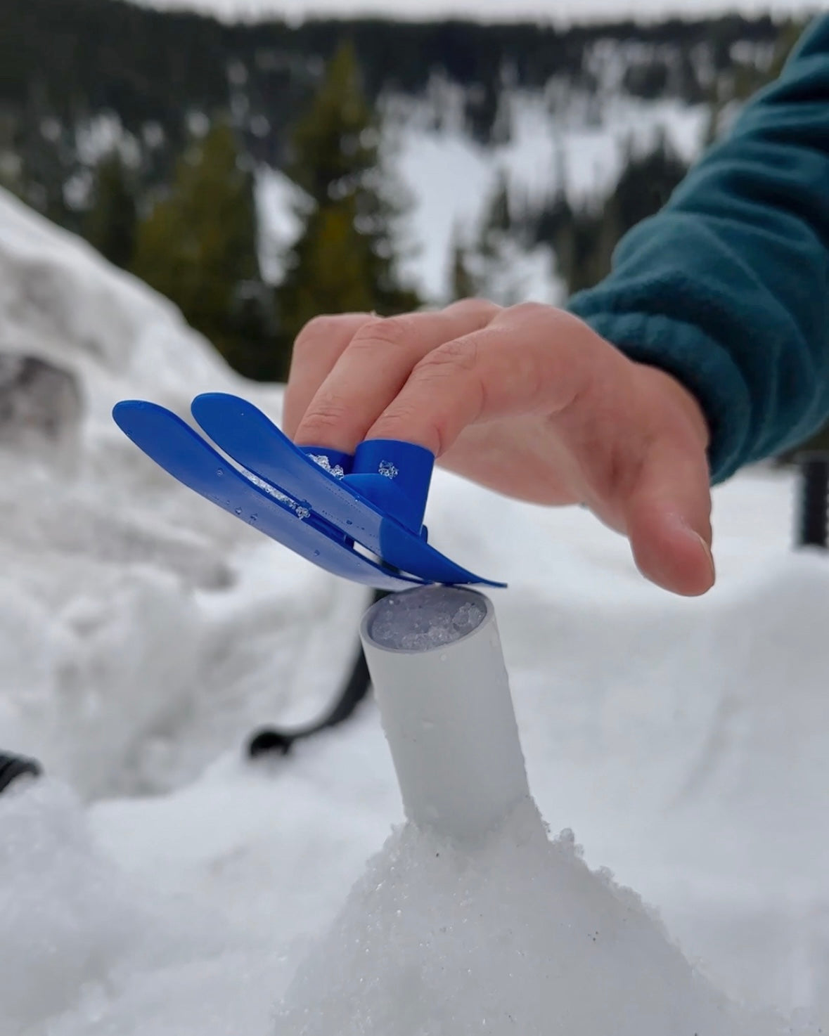 slideofhand finger ski blue being used on a tube rail in snow