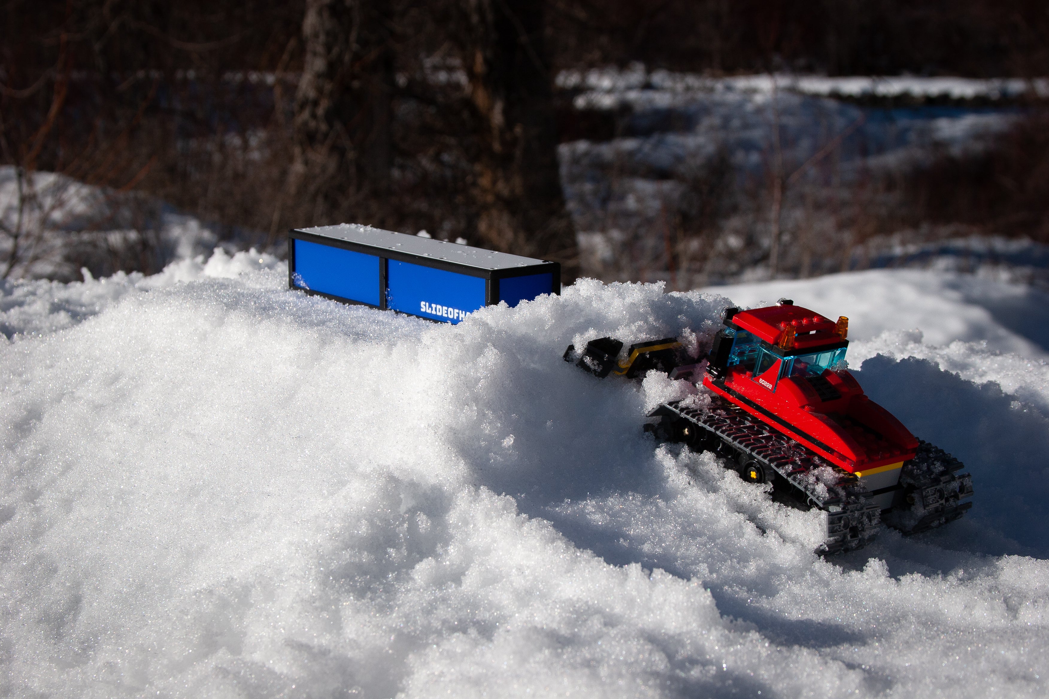 slideofhand finger ski box rail sitting on snow next to a lego snowcat