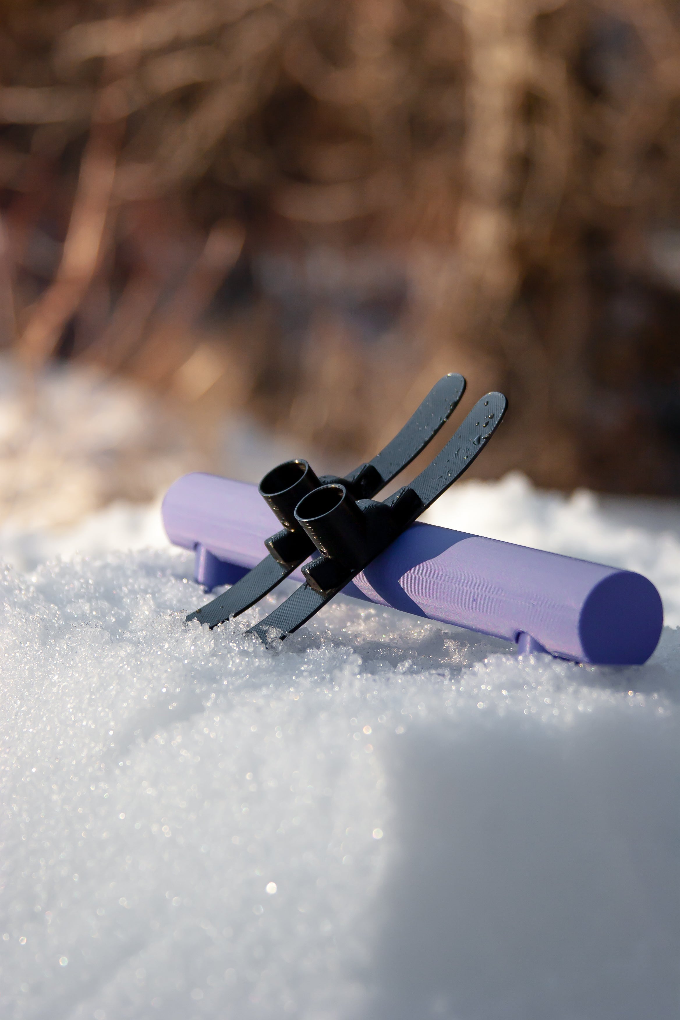 slideofhand finger ski black resting up against a turbo tube terrain park rail purple on snow