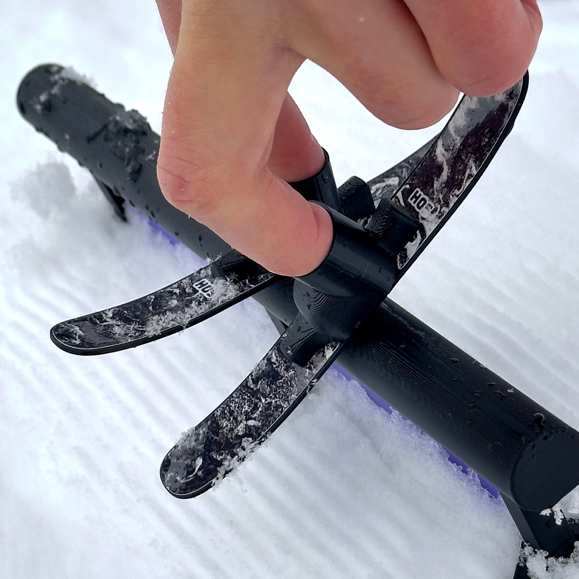 SlideofHand Finger Skis Pollen Graphic being used on a walled tube rail top down side profile in snow